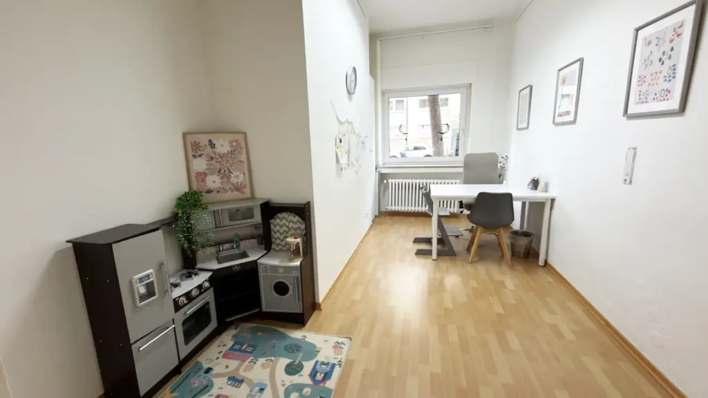 Heller Behandlungsraum für Kinder in der Praxis LogoBilingua in Köln-Nippes mit Therapietisch und Spielbereich